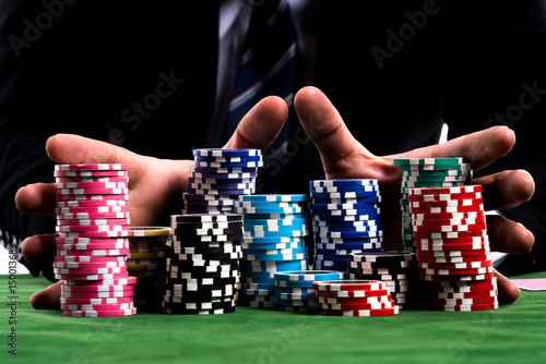 A poker Player hands pushing in all his chips to betting