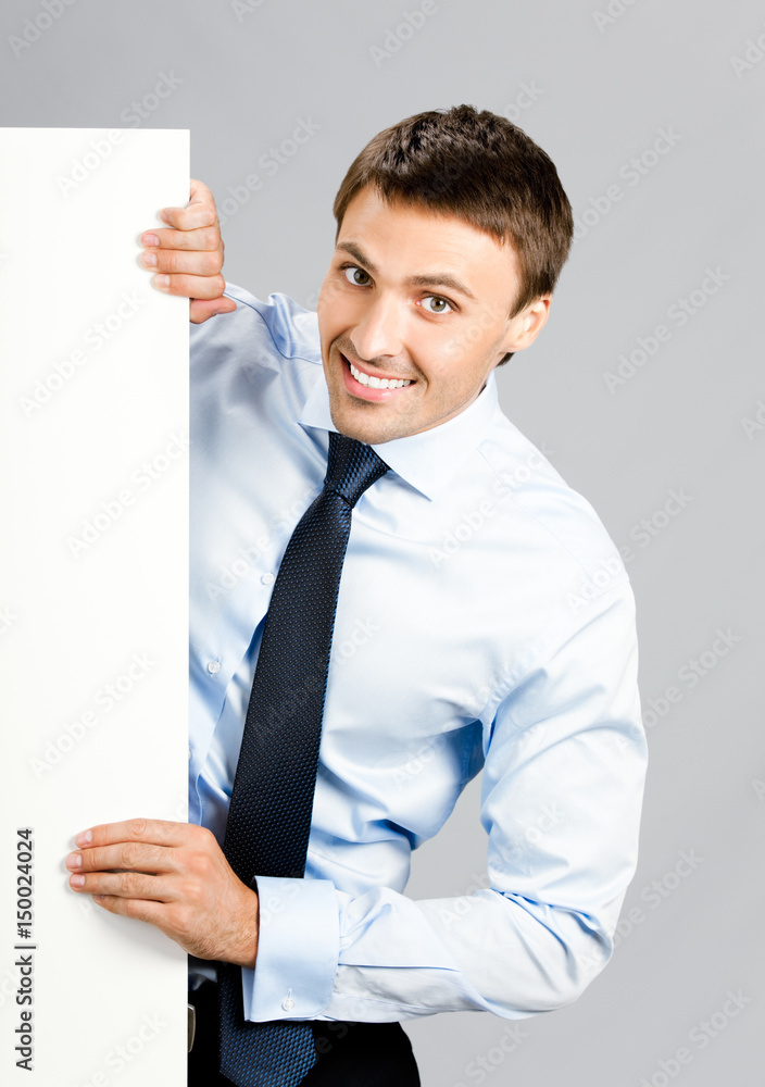 Business man showing blank signboard, over gray Business man showing blank signboard, over gray