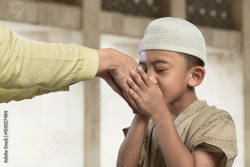 Asian muslim child kissing a hand from an old people