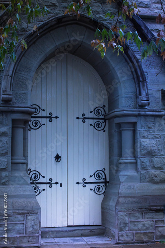 Ghostly old church doors with wrought iron hinges and doorknob photo