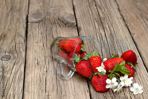 Fresh strawberries in glass Cup on old wooden table.