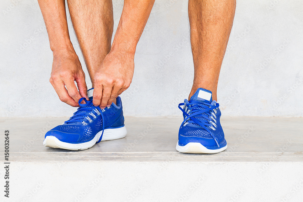 Man lacing sport shoes in gym, sport exercise concept