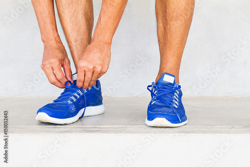 Man lacing sport shoes in gym, sport exercise concept