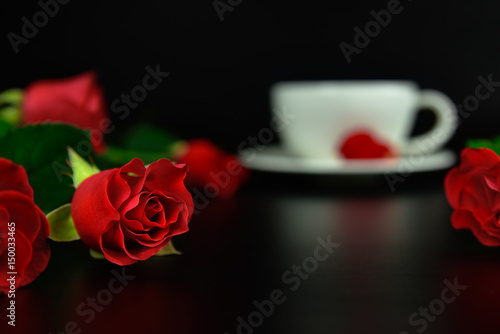 Red rose with cup of coffee in the evening.