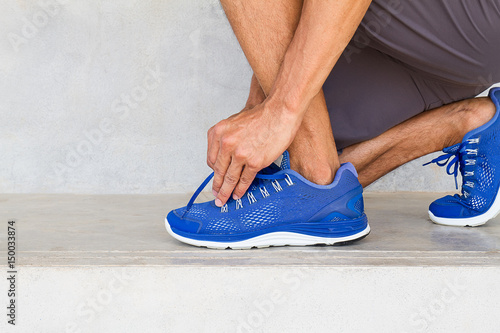 Man lacing sport shoes in gym, sport exercise concept