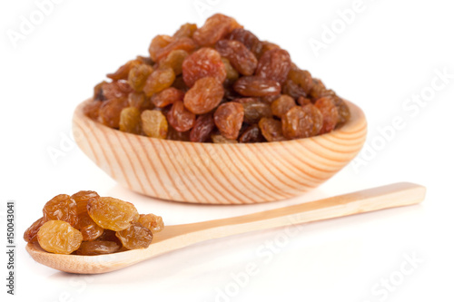 raisins in a wooden bowl with spoon isolated on white background