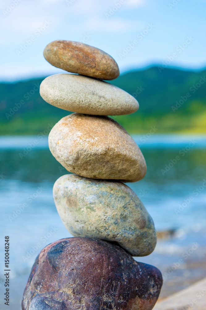 Photo of stones balanced on top of eachother on a beach Photo of stones balanced on top of eachother on a beach