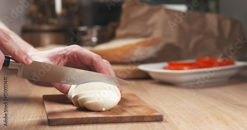 young man hands slicing mozzarella cheese, 4k photo