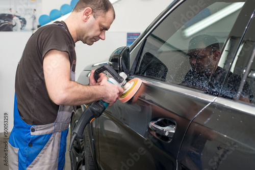 A man polishes a black car