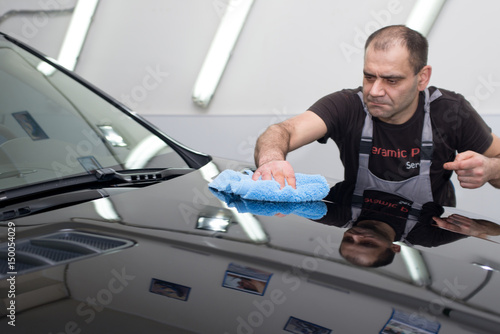 A man polishes a black car © zhekkka