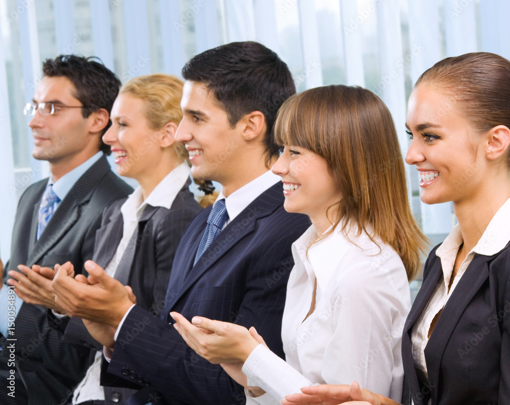 Clapping businesspeople at presentation
