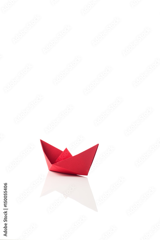 Red paper ship on white with reflection Red paper ship on white with reflection
