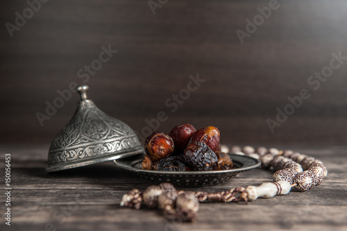 Ramadan of islam, date palm for Ramadan, date palm fruits and Tea on a metal tray placed on wood background. photo