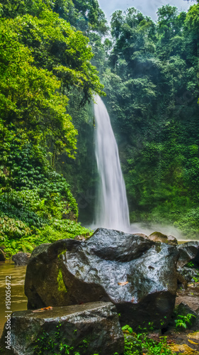 Amazing Nungnung waterfall, Big stone in front, Bali, Indonesia © Igor Tichonow