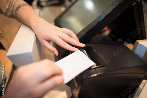 Photos Young woman printing some invoice / receipt for a costumer at huge shopping cent