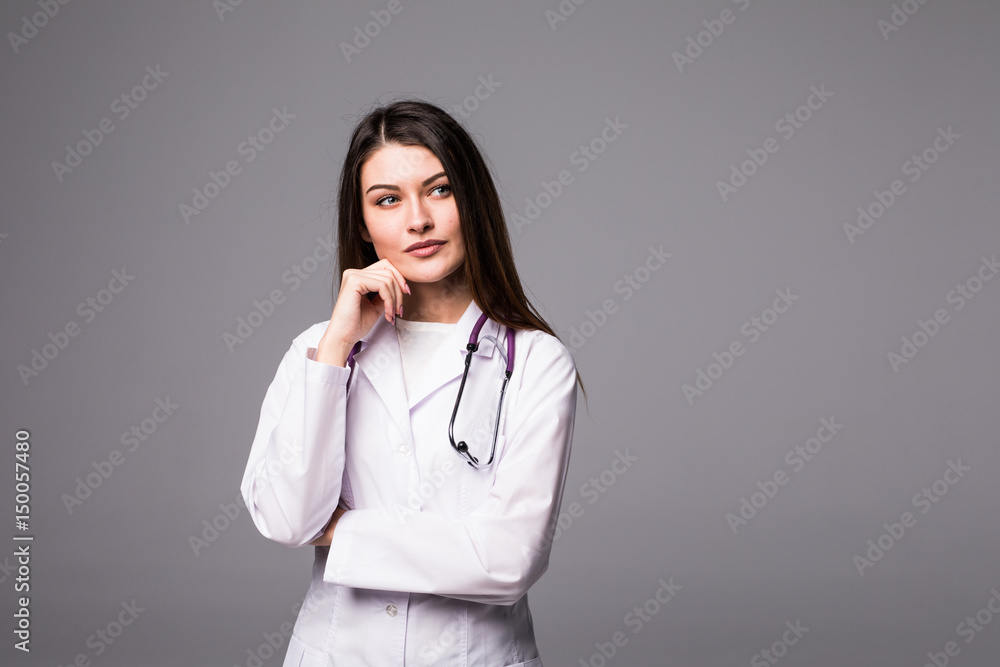 Thoughtful, Young female doctor looking away isolated on grey background Thoughtful, Young female doctor looking away isolated on grey background