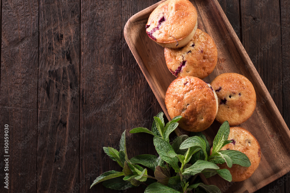 Fototapeta premium Blueberry muffins with fresh berries on old wooden background