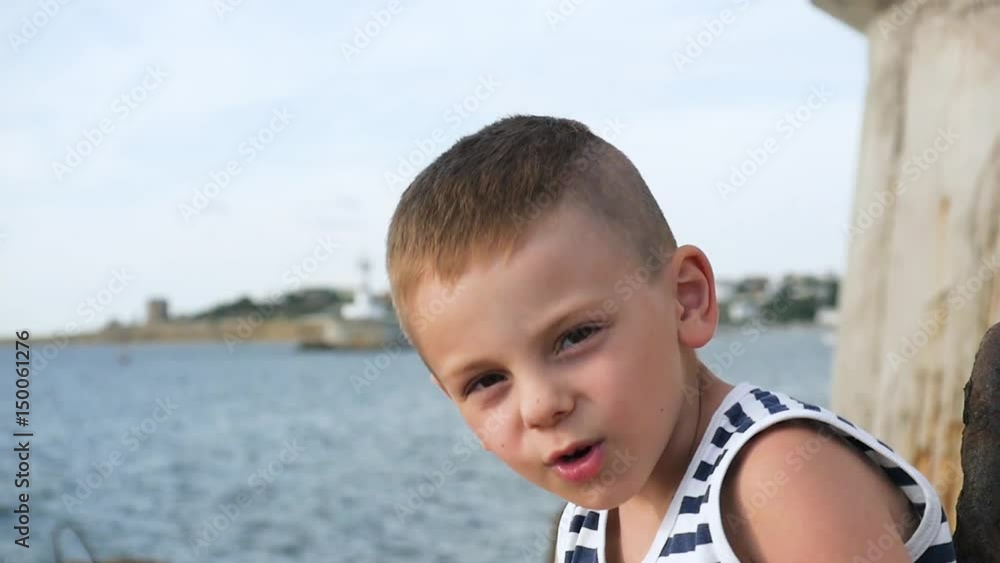 happy little boy in sailor stripes shirt on sky and sea background happy little boy in sailor stripes shirt on sky and sea background