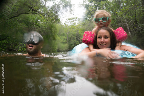 Mother, father and daughter with inflatable ring in lake, Niceville, Florida, USA photo