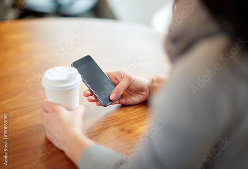 close up of woman with smartphone and coffee at cafe