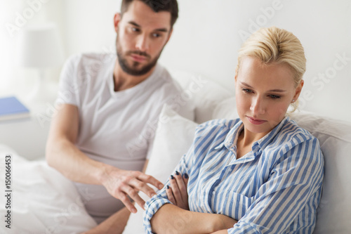 unhappy couple having conflict in bed at home