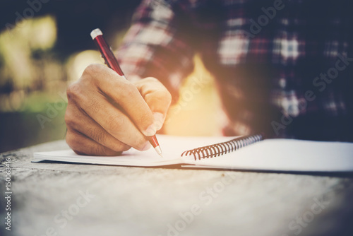 Hand writing note on marble table in the park.