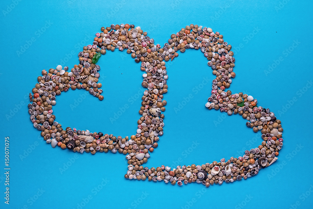 Seashell frame 'Heart' on blue paper background. Seashell frame 'Heart' on blue paper background.