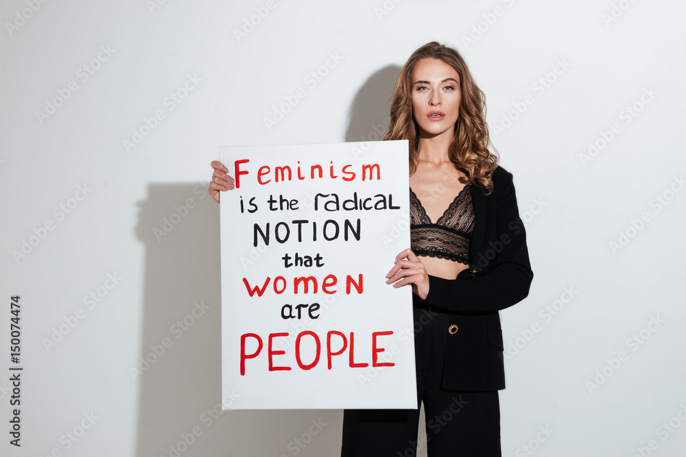Attractive young caucasian lady holding blank with text about feminism. Attractive young caucasian lady holding blank with text about feminism.