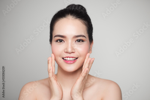 Asian woman touching her face.
