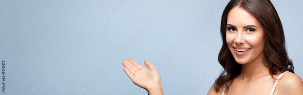 Woman in showing copyspace or something, on grey Woman in showing copyspace or something, on grey