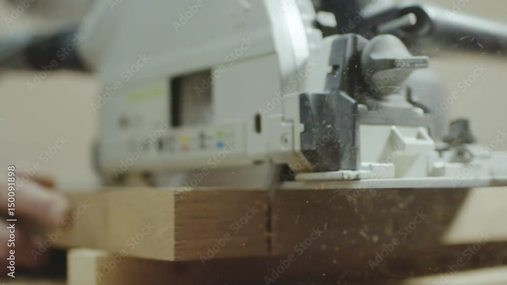 Man cutting a wooden plank Man cutting a wooden plank