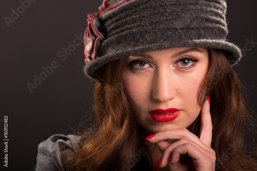 Vintage style portrait of beautiful young woman wearing cloche hat.