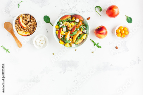 Breakfast with muesli, peach salad, fresh peaches, on white background. Healthy food concept. Flat lay, top view