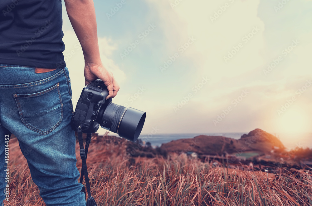 Close-up shot of man  holding camera  standing on the hill - obrazy, fototapety, plakaty 