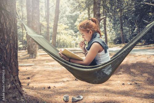 Women sitting reading. In the hammock. In the natural atmosphere in the park