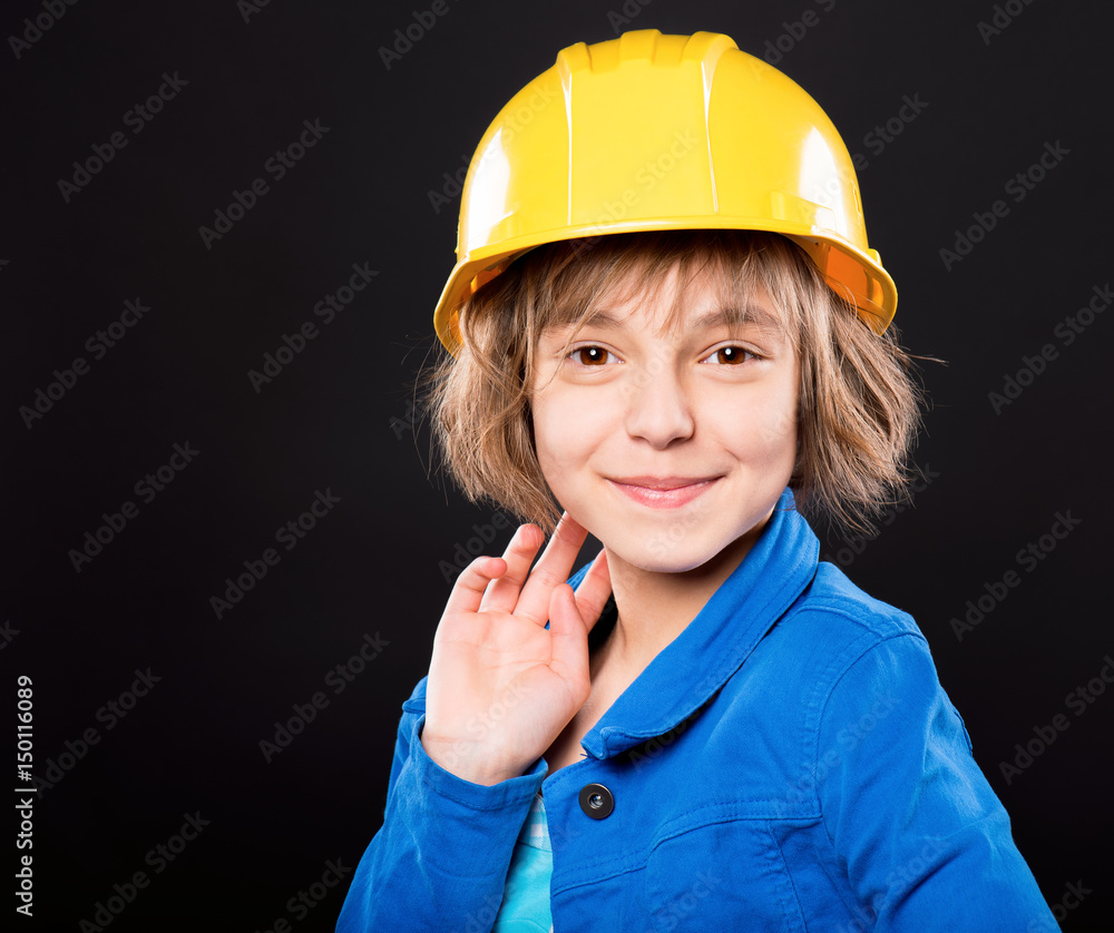 Emotional portrait of attractive caucasian girl wearing safety yellow hard hat. Beautiful happy child looking at camera and smiling, on black background. Emotional portrait of attractive caucasian girl wearing safety yellow hard hat. Beautiful happy child looking at camera and smiling, on black background.