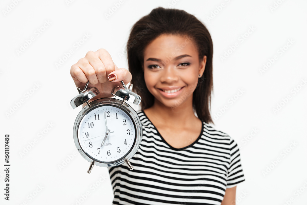 Portrait of a happy african teen girl showing alarm clock Portrait of a happy african teen girl showing alarm clock