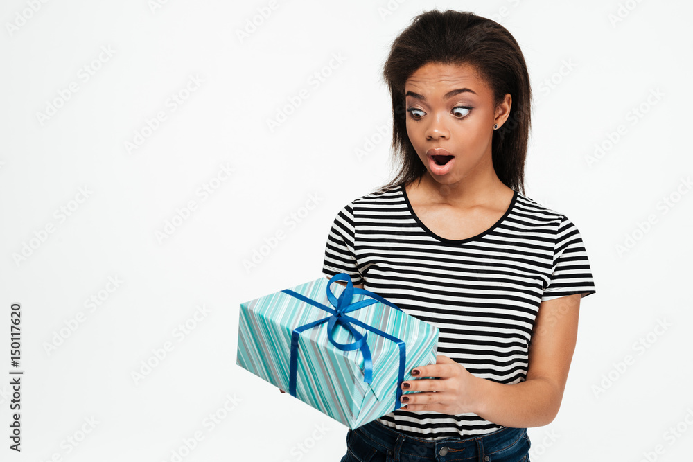 Afro american teenager girl holding and looking at present box Afro american teenager girl holding and looking at present box