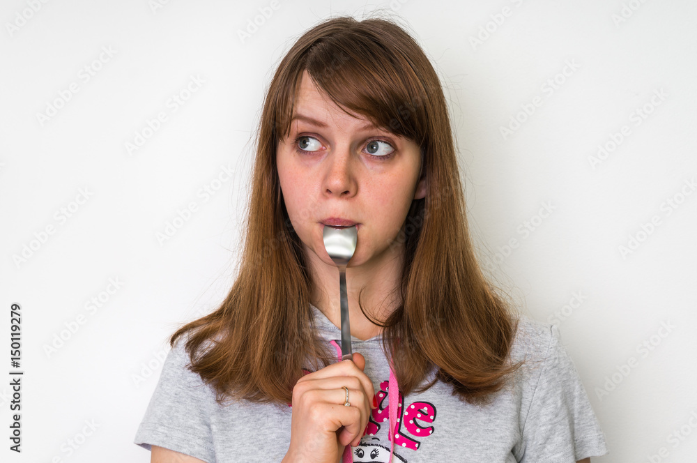 Young beautiful woman with spoon in mouth Young beautiful woman with spoon in mouth