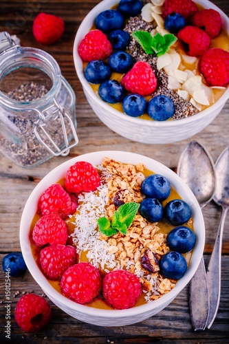 Tropical smoothie bowls with raspberries, blueberries, chia seeds and granola