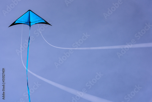 Blue kite floating in the blue sky. Kite with blue sky background.