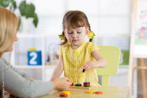 kid and mother playing together with puzzle toy