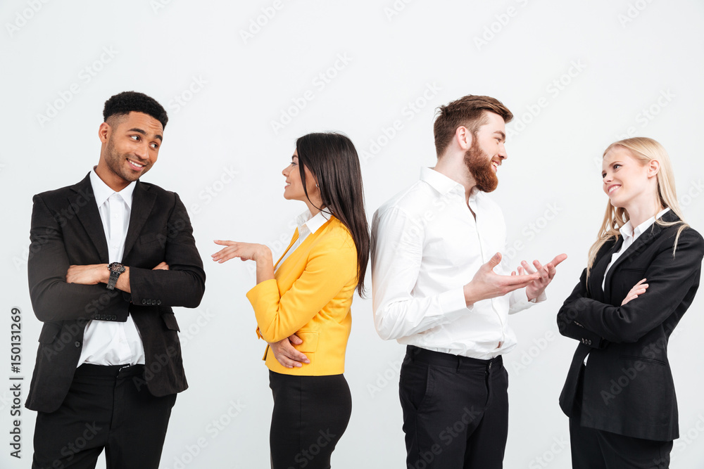 Happy colleagues business team standing in office and talking Happy colleagues business team standing in office and talking