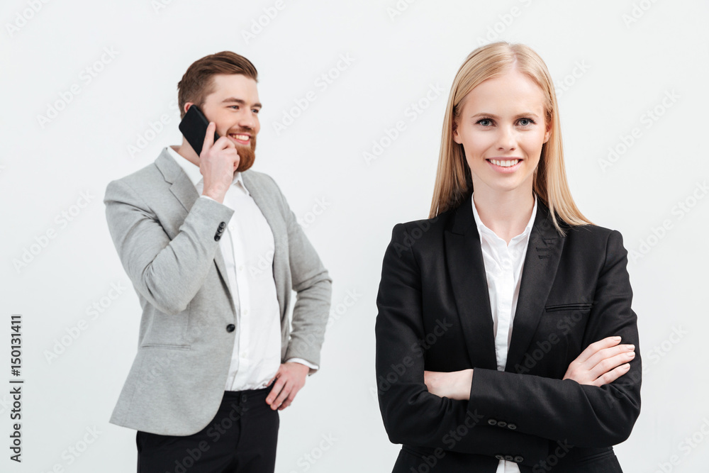 Happy lady standing near her colleague man talking by phone Happy lady standing near her colleague man talking by phone