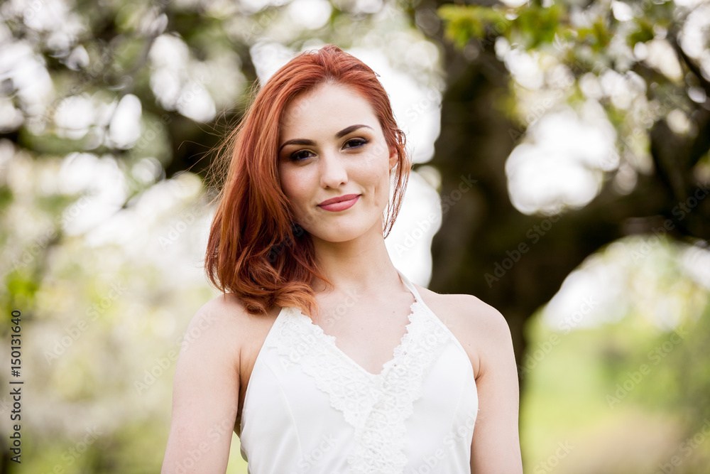 Gorgeous redhead woman in outdoor photo in sunny summer day. Beautiful girl in springtime Gorgeous redhead woman in outdoor photo in sunny summer day. Beautiful girl in springtime