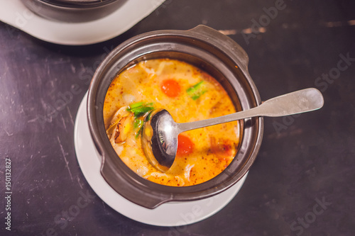 Tom yam kong or Tom yum, Tom yam is a spicy clear soup typical in Thailand and No.1 Thai Dish Cuisine. Tom yam kong on wooden table. Thai food photo