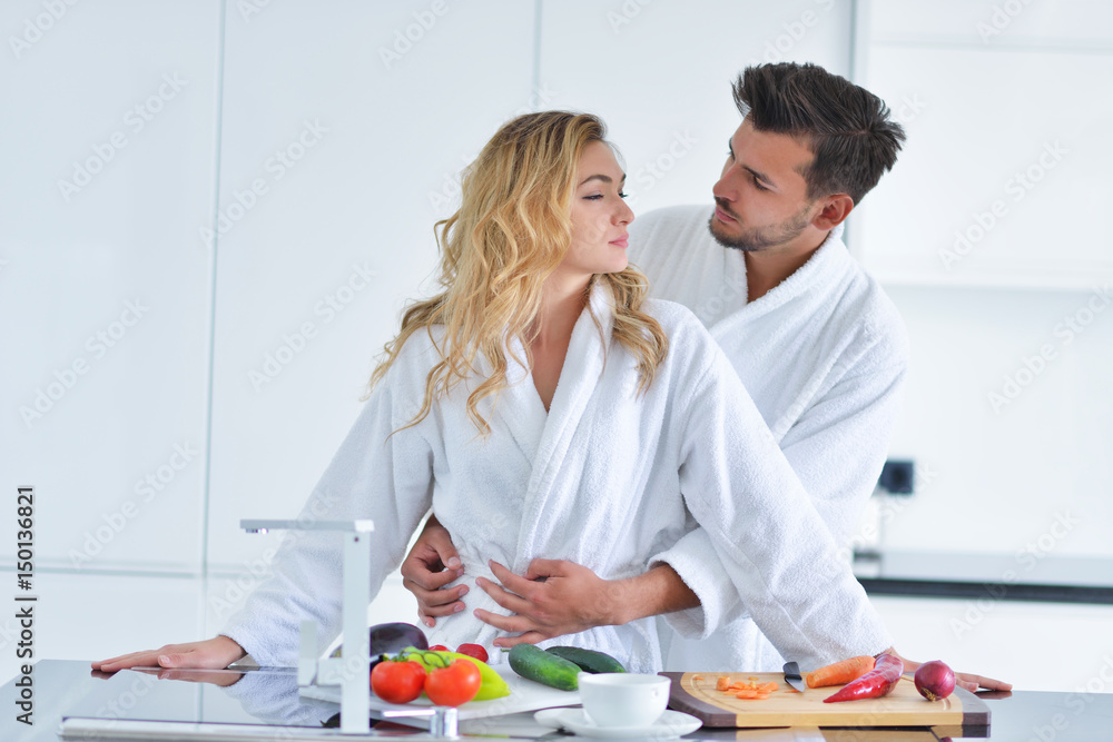 Happy couple cooking breakfast together in the kitchen Happy couple cooking breakfast together in the kitchen