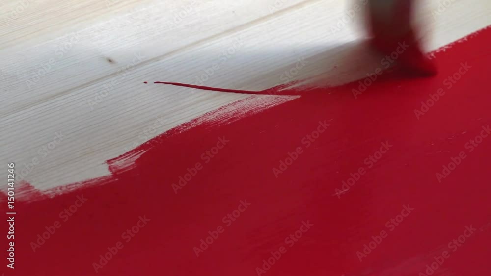 Man paints a wood desk with red paint. Close-up. Man paints a wood desk with red paint. Close-up.