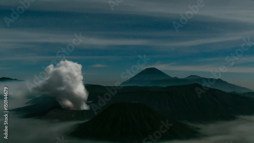 Volcanic smoke over Mountain Bromo and surround by fog in nighttime at Bromo tengger semeru national park, East Java, Indonesia
