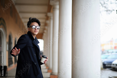 Photography Asian young man in a coat on the street